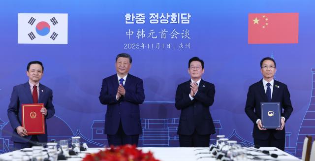 유재성 경찰청장 직무대행과 다이빙 주한중국대사가 1일 경북 국립경주박물관에서 이재명 대통령과 시진핑 중국 국가주석이 참석한 가운데 보이스피싱ㆍ온라인 사기범죄 대응 공조 양해각서를 체결하고 있다사진연합뉴스