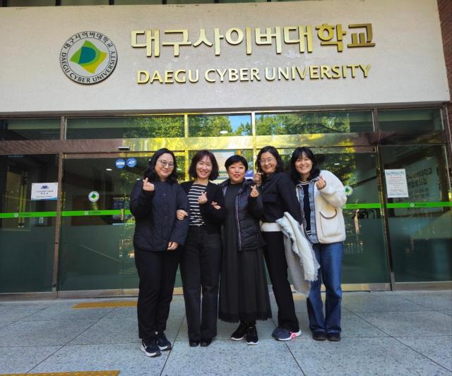 임지향 교수가운데와 해외에 거주하고 있는 미술치료학과 학생들이 캠퍼스를 배경으로 기념촬영 하고 있다 사진대구사이버대학교