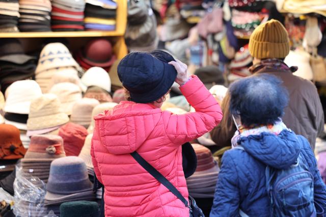 서울 아침 기온이 4도까지 떨어지면서 초겨울 날씨를 보인 27일 서울 남대문시장 상점에서 방한용품을 판매하고 있다 사진연합뉴스