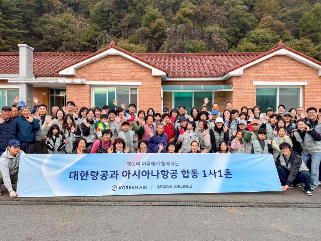 봉사활동에 참여한 대한항공·아시아나항공 양사 임직원과 가족들이 명동리 주민들과 기념사진을 촬영하는 모습 사진대한항공