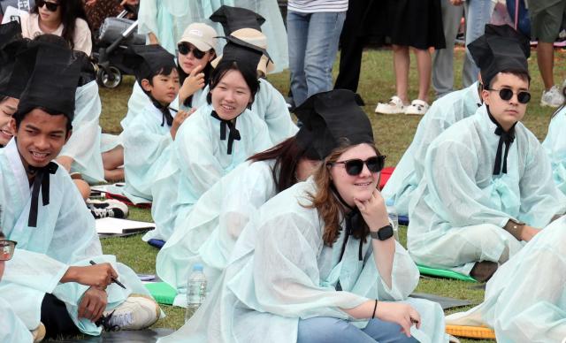 세종시 대표 가을 축제인 세종한글축제가 10월 9일 호수공원 일대에서 개막해 사흘간 일정에 들어갔다 조선시대 과거시험 체험에 참여한 외국인과 어린이들이 한글 세종대왕 등과 관련한 문제를 풀고 있다 사진연합뉴스