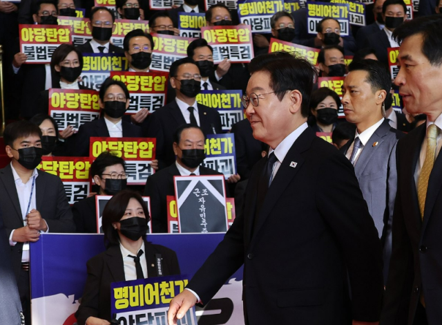 이재명 대통령이 지난 4일 내년도 정부 예산안에 대한 시정연설을 하기 위해 서울 여의도 국회에 도착해 침묵시위를 하는 국민의힘 의원들 앞을 지나고 있다 국민의힘 의원들은 추경호 전 원내대표에 대한 내란 특검팀의 영장청구를 규탄하는 피켓을 들고서 침묵시위를 했다 사진연합뉴스