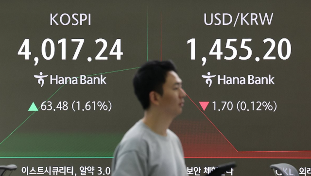 An employee walks past a display board showing exchange rates at Hana Bank’s main office in central Seoul on Nov 10 2025 Yonhap