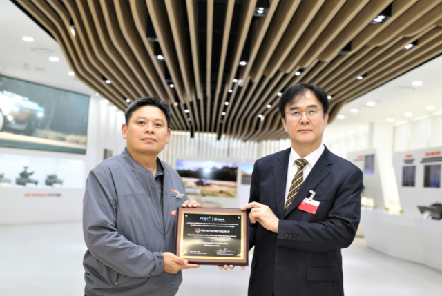 Giám đốc điều hành Hanwha Aerospace Ahn Hong-gyu trái và kiểm toán viên cấp cao CMMI High Maturity Jeong Sang-wook đại diện ITQC chụp ảnh kỷ niệm sau khi được cấp chứng nhận Ảnh  Hanwha Aerospace