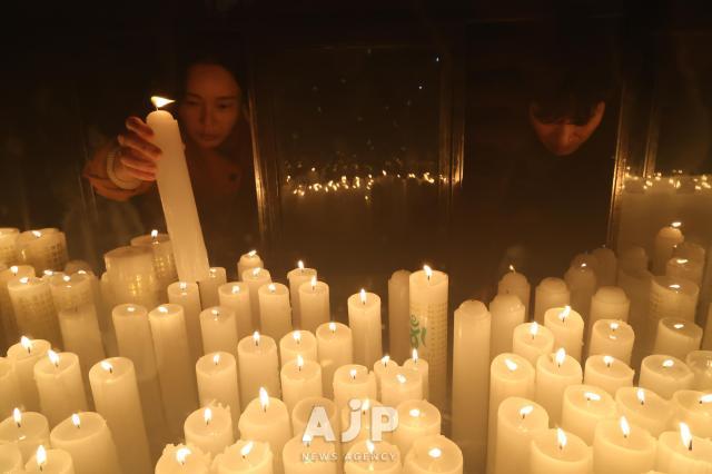 12일 서울시 강남구 봉은사에서 신도들이 수험생의 고득점을 기원하는 초를 올리고 있다