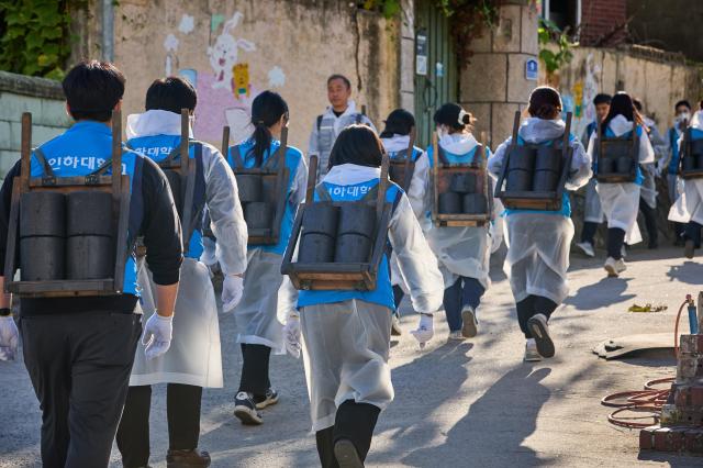 ‘대한민국 1도 올리기 사랑의 연탄 나눔’ 행사 참여자들이 연탄을 배달하고 있다 사진인하대