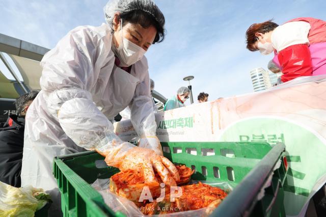 17일 서울 송파구 가락몰에서 열린 2025 가락시장 김장나눔 시민대축제에서 참가자가 김치를 통에 넣고 있다 AJP Yoo Na-hyun