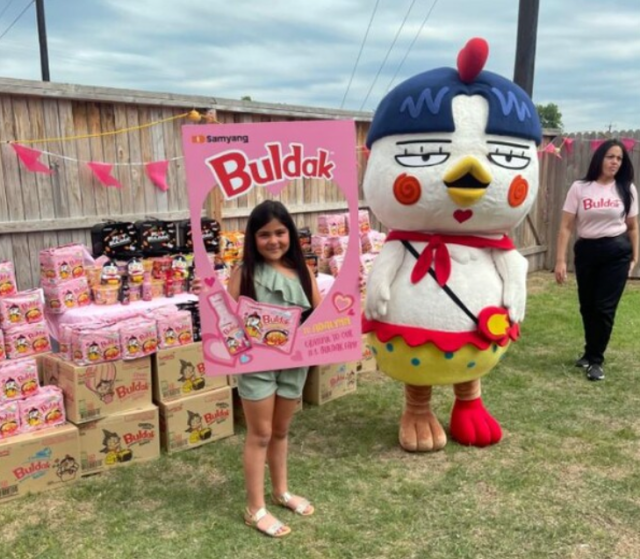 Adalynn Sofia from Texas smiles in her backyard which is decorated with a Buldak Carbonara Ramen theme Courtesy of Samyang Foods