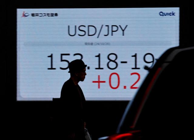 일본 도쿄의 한 증권사 외벽 전자 화면에 표시된 엔·달러 환율 앞을 한 행인이 지나가고 있다 사진로이터연합뉴스