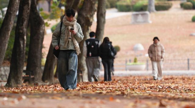Một sinh viên quàng khăn dạo quanh khuôn viên trường Đại học Quốc gia Kyungpook ở Buk-gu Daegu vào ngày 17 tháng 11 năm 2025 ẢnhYonhap News