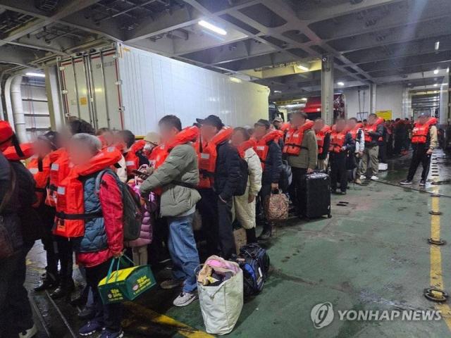 Passengers wearing life jackets prepare to disembark from the Queen Jenuvia 2 after the ferry ran aground at Jokdo in Jangsan-myeon Sinan County in South Jeolla at about 816 pm on Nov 19 