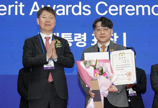 최우혁 산업통상자원부 국장과 김철 HS효성종합기술원 전무가 카본 코리아 2025에서 대통령상 수상 기념 촬영을 하고 있다 사진HS효성
