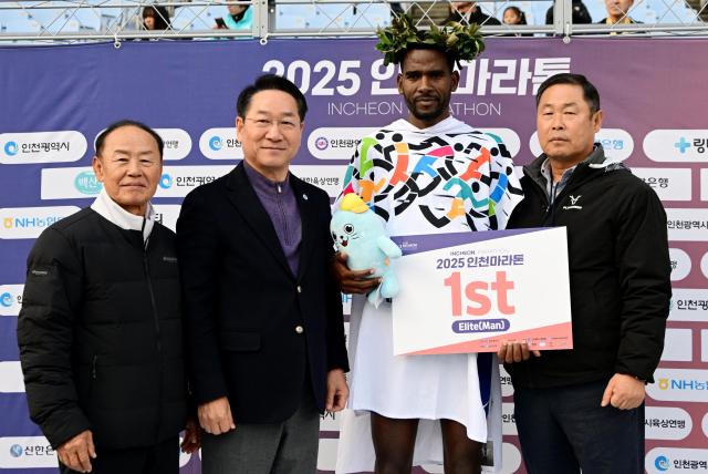 유정복 인천광역시장이 23일 문학경기장에서 열린 2025 인천마라톤에서 우승 선수에게 월계관을 씌워주고 있다 사진인천시