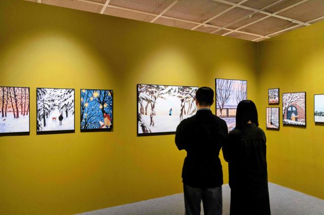 서울시 송파구 잠실동에 위치한 롯데백화점 잠실점 에비뉴엘 6층 아트홀에서 고객이 겨울 그 따뜻한 순간들 전시를 구경하고 있다 사진롯데백화점