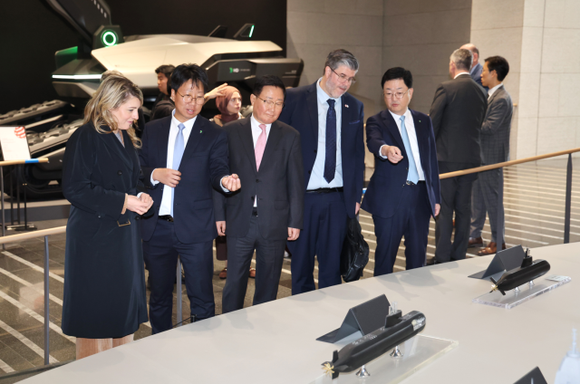멜라니 졸리 캐나다 산업부 장관과 필립 라포튠 주한 캐나다 대사 일행이 조석 HD현대 부회장 주원호 HD현대중공업 사장과 함께 25일 경기 판교에 위치한 HD현대 글로벌RD센터에서 미래형 선박·잠수함·호위함 등 함정 모형을 둘러보고 있는 모습이다 사진HD현대