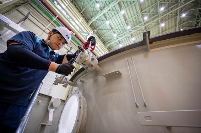 Worker assembling a high-voltage transformer at LS Electric's Busan facility