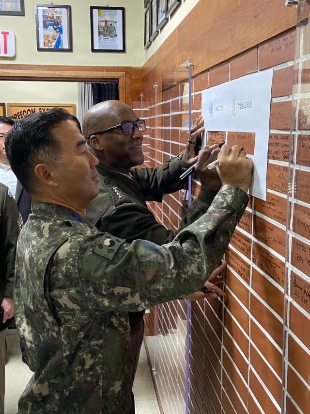 진영승 합참의장과 제이비어 브런슨 유엔군사령관이 27일 미국 추수감사절을 맞아 유엔사 경비대대를 방문해 방명록을 남기고 있다 사진유엔사