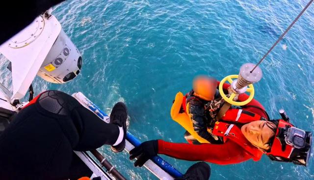 전복된 소형 어선의 선장 1명을 헬기로 안전하게 구조하고 있다 사진동해해경청