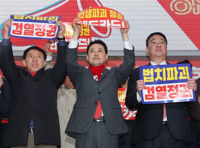 장동혁 국민의힘 대표를 비롯한 당 지도부 소속 의원들이 25일 구미역 광장에서 열린 민생회복과 법치수호 경북 국민대회에서 팻말을 들고 있다 사진연합뉴스