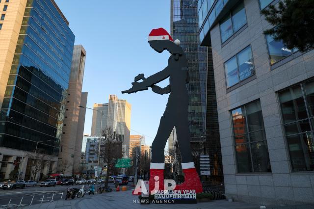 A “Hammerman” sculpture dressed in a Santa costume stands in front of a building in Seoul’s Jongno District on Dec 1