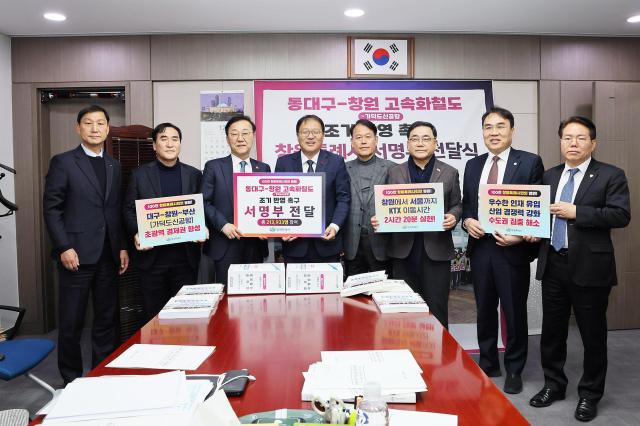 장금용 창원특례시장과 창원 지역 국회의원 등이 동대구-창원 고속화철도 개통 서명부를 들고 기념촬영을 하고 있다사진창원시