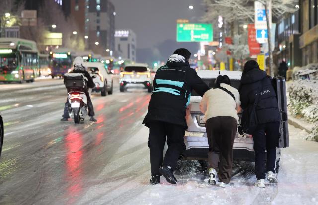  People pushing car in Mapo Seoul Dec 4 2025 Yonhap
