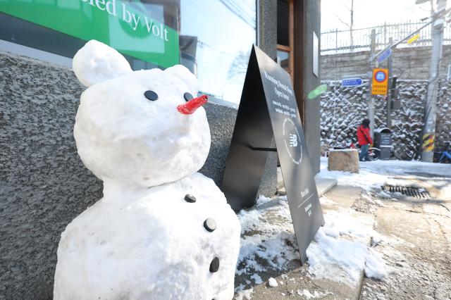A small snowman sits in front of a hanok in Bukchon Jongno District Seoul on December 5 2025 AJP Han Jun-gu