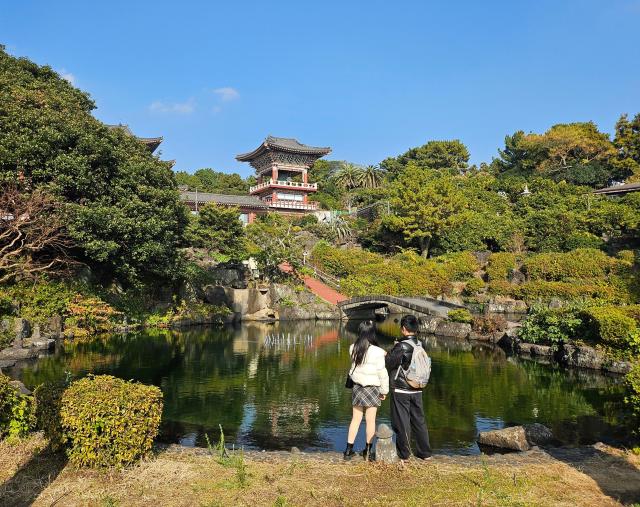 Tourists stroll through Yakcheonsa Temple in Seogwipo Jeju on Dec 7 2025 Yonhap