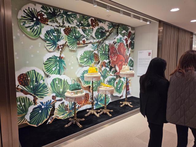 고객들이 9일 서울 중구 롯데백화점 본점에 전시된 프랑스 일러스트레이터 나탈리 레테의 작품을 관람하며 지나가고 있다 사진조재형 기자