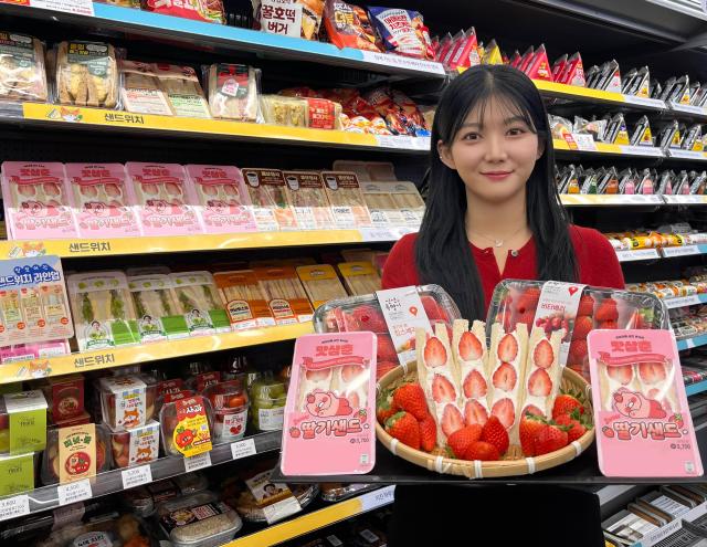GS25에서 모델이 맛삼춘 딸기샌드위치와 생딸기를 들고 포즈를 취하고 있다사진GS25
