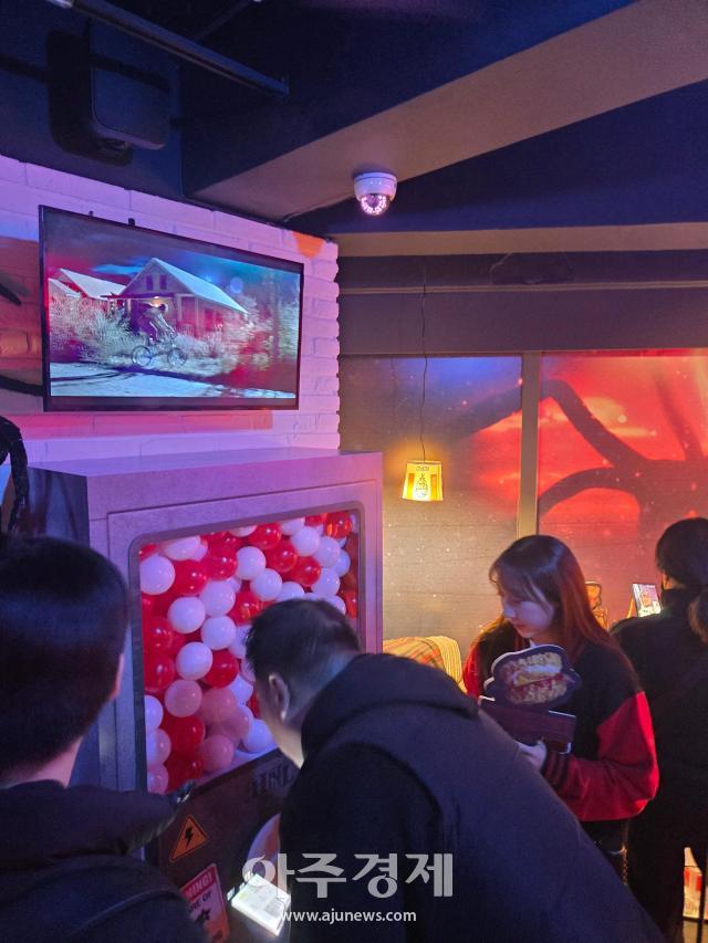 기묘한 이야기 콜라보 팝업에서 가챠를 뽑고 있는 참가자 사진박승호 기자