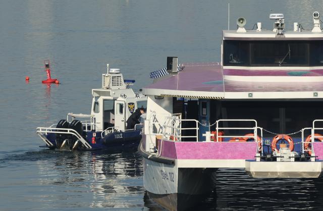 지난달 16일 서울 송파구 잠실선착장 부근 강바닥에 걸려 멈춘 한강버스와 주변 등대에서 경찰이 사고조사를 하고 있다 사진연합뉴스