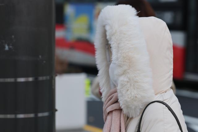 서울 아침 기온이 영하 7도까지 내려가며 강추위가 찾아온 3일 서울 종로구 광화문네거리에서 외투 모자를 쓴 시민이 이동하고 있다