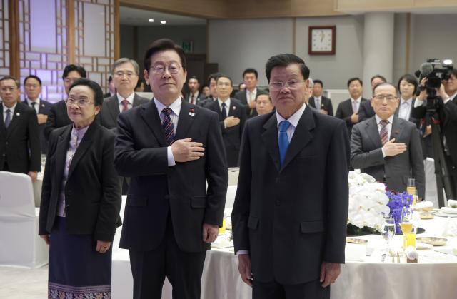 이재명 대통령이 15일 용산 대통령실에서 열린 한-라오스 공식오찬에서 국민의례를 하고 있다사진연합뉴스