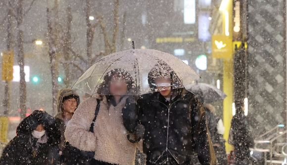 지난 4일 서울 마포구 홍대 부근에 눈이 내리는 가운데 시민들이 이동하고 있다 사진연합뉴스
