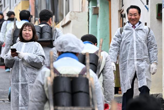 유정복 인천광역시장이 16일 서구 석남동에서 열린 2025 사랑나눔 연탄 봉사에서 인천광역시공무원노동조합원 등 자원봉사자들과 연탄을 나르고 있다 사진인천시