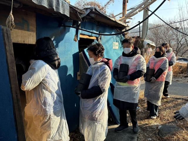 자생한방병원 임직원들이 사랑의 연탄 나누기 행사에 참석해 연탄을 나르고 있다사진자생한방병원