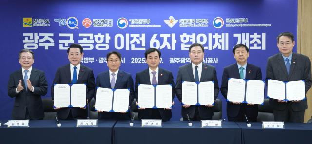 김영록 전라남도지사가 17일 광주에서 열린 ‘광주 군 공항 이전 6자 협의체’ 회의에서 구윤철 기획재정부장관 안규백 국방부장관 강희업 국토교통부2차관 강기정 광주광역시장 김산 무안군수와 공동 발표문에 서명한 뒤 기념촬영을 하고 있다사진전남도