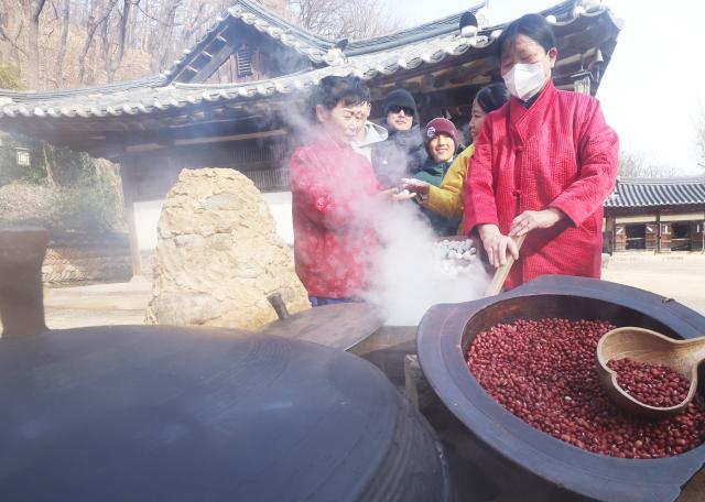 절기상 동지를 하루 앞둔 21일 경기도 용인시 한국민속촌에서 직원들이 팥죽을 쑤고 있다 사진연합뉴스