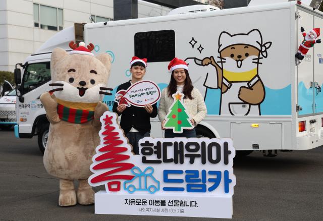 현대위아 직원들이 지난 23일 경상남도 창원시 현대위아 본사 앞에서 지역 사회복지기관 10곳에 선물할 ‘현대위아 드림카’와 함께 기념 사진을 찍고 있다 현대위아 제공