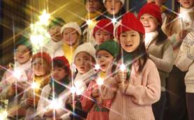 Childrens choir lights candles for Christmas