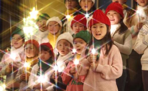 Childrens choir lights candles for Christmas