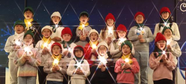 Children’s choir members sing carols while holding candles to bless the baby Jesus at Seoul Gwangyeom Church in Nowon District northern Seoul Dec 18 Yonhap