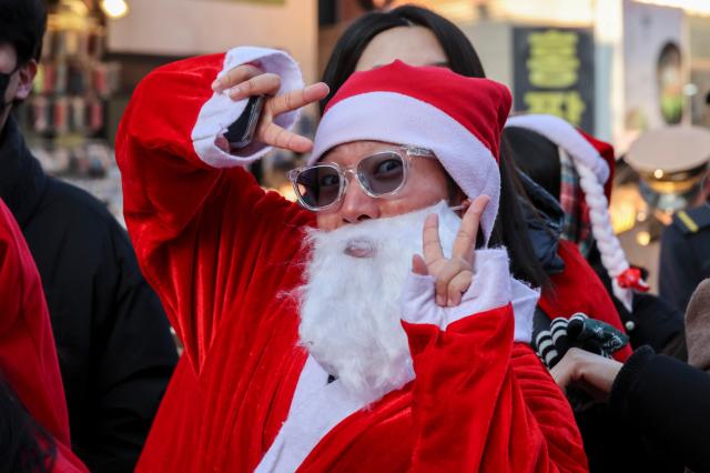 24일 서울 서대문구 연세로에서 열린 '2025 사랑의 몰래 산타 대작전' 출정식에 참가한 자원봉사자가 포즈를 취하고 있다. AJP Yoo Na-hyun