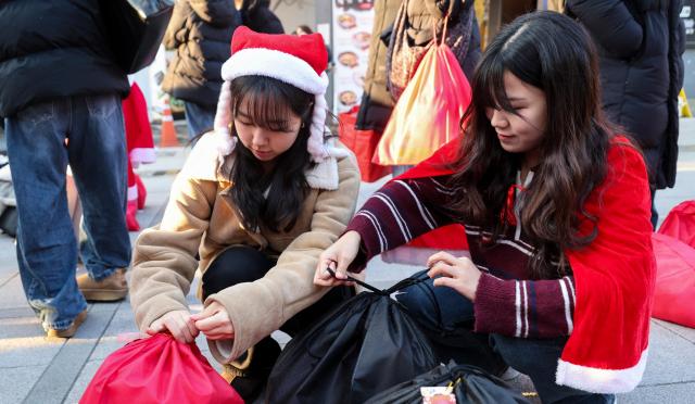 24일 서울 서대문구 연세로에서 열린 ‘2025 사랑의 몰래산타 대작전’ 출정식에서 자원봉사자들이 선물을 포장하고 있다 AJP Yoo Na-hyun