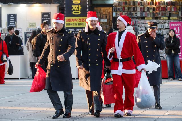 24일 서울 서대문구 연세로에서 열린 ‘2025 사랑의 몰래산타 대작전’ 출정식을 마친 자원봉사자들이 선물을 전달하기 위해 이동하고 있다 AJP Yoo Na-hyun