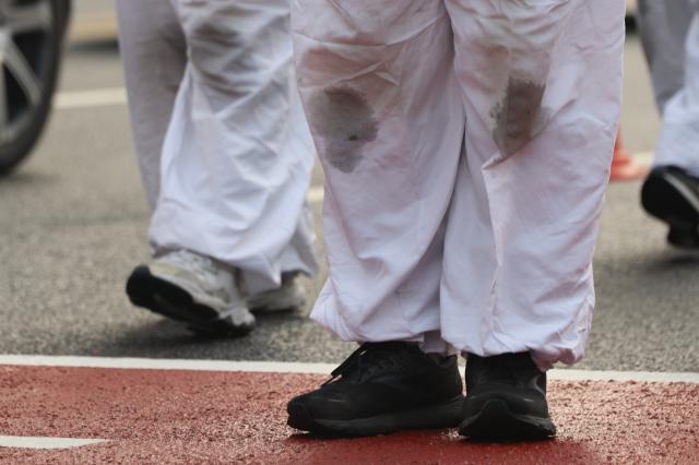 Protesters’ knees are visibly stained black during a demonstration march at Gwanghwamun Square in Seoul on Dec 29 2025 AJP Han Jun-gu