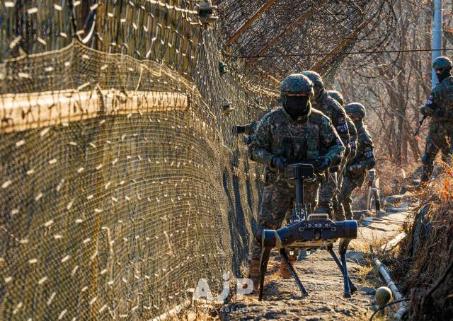 Soldiers of the Army’s 5th Infantry Division patrol along the barbed-wire fence with a quadrupedal robot under trial deployment near the inter-Korean border AJP Yoo Na-hyun