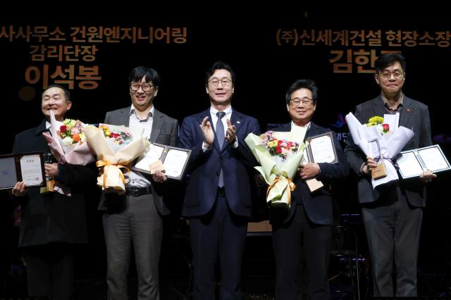 정명근 화성특례시장이 화성예술의 전당 개관기념 제야 콘서트에서 유공자들에게 특별 공로패 및 감사패를 전라하고 기념촬영을 하고 있다 사진화성시