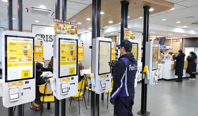 A man orders food at a kiosk inside a fast-food restaurant in Seoul AJP Yoo Na-hyun